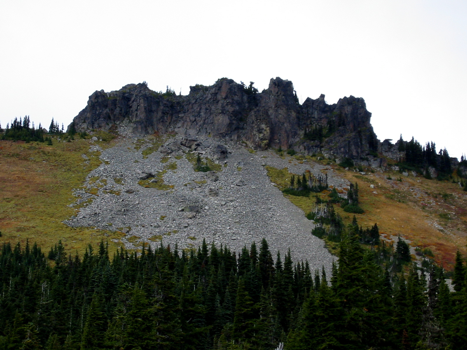 Grass and rock slopes lead up to the broad jagged ridge of Hessong Rock