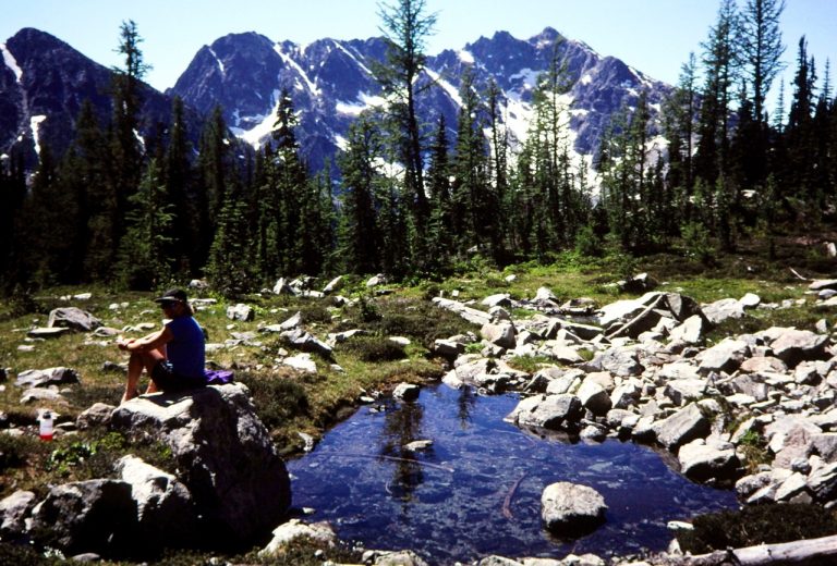 A hike pauses at Stiletto Knob below Stiletto Peak