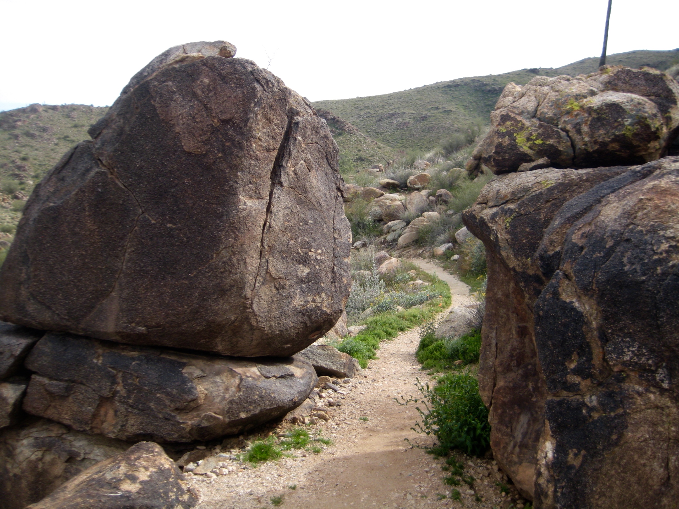 The Mesquite Canyon Trail passes between two large desert boulders in White Tank Mountains of Arizona