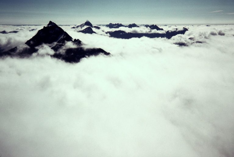 The sharp summits of Mt Pugh and Sloan Peak poke upward through a sea of clouds seen from White Chuck Mtn