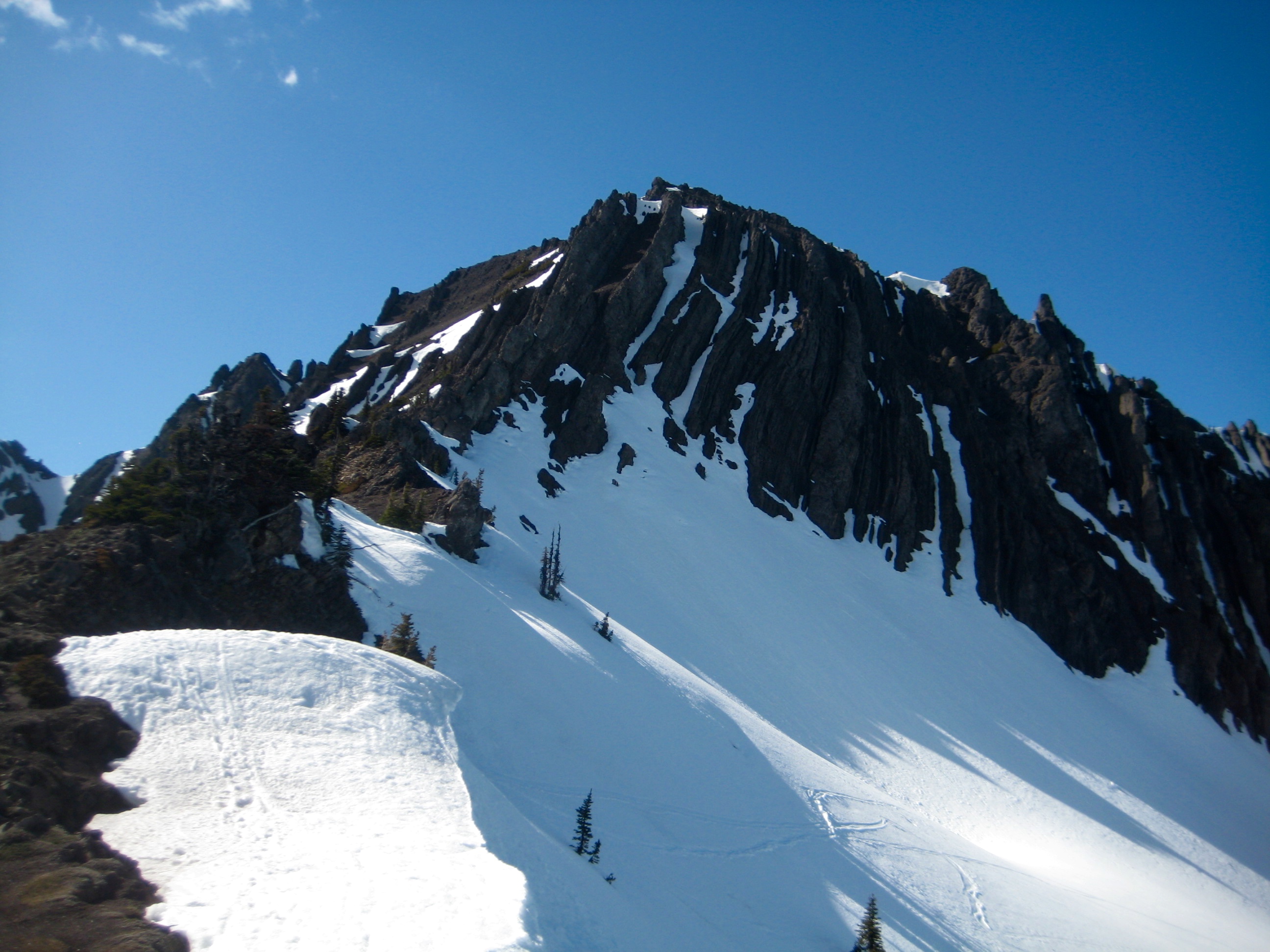Steep snow slopes lead up to the dark rocky summit of Mt Angeles in the Olympic Mountain National Park