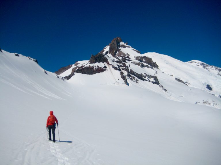 Climber snowshoeing towards Whitman Notch and Little Tahoma Peak