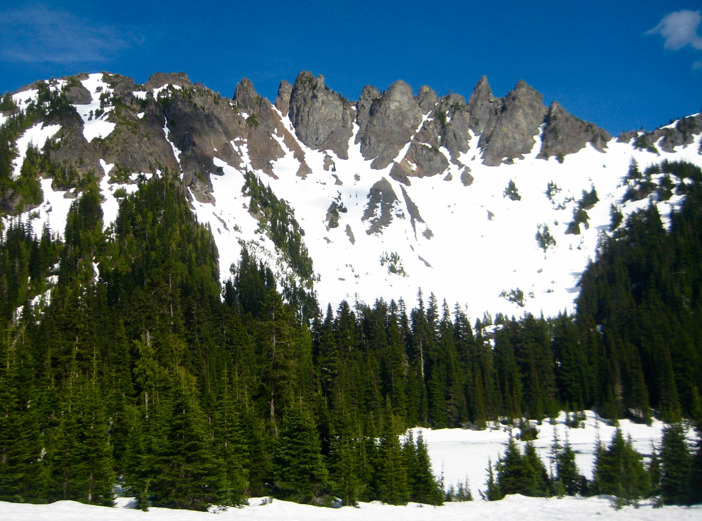 The craggy ridge of Governors Ridge stands above snow-covered Owyhigh Lake in Mt Rainier National Park