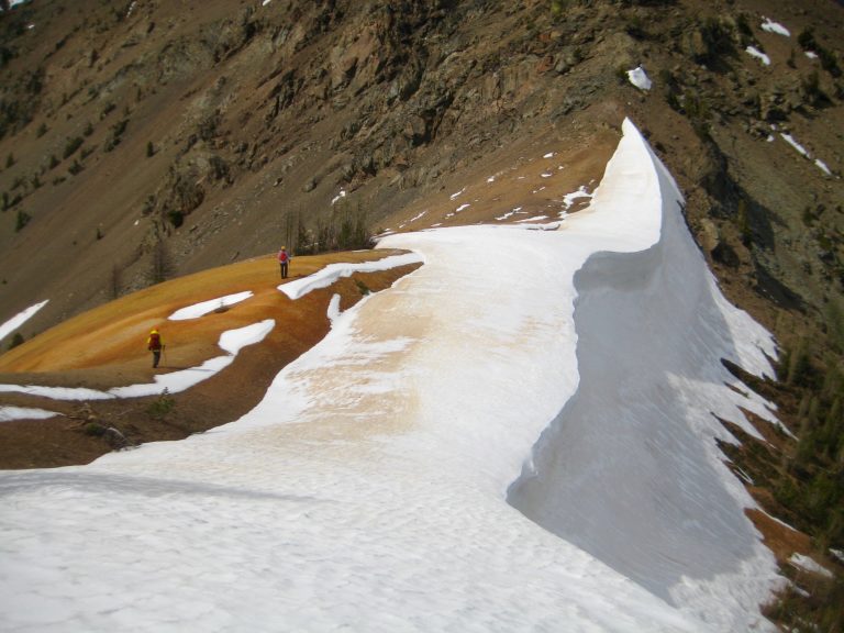 climbers hiking across Red Saddle with snow cornice in the Mazama Mountains near Scatter Creek Basin