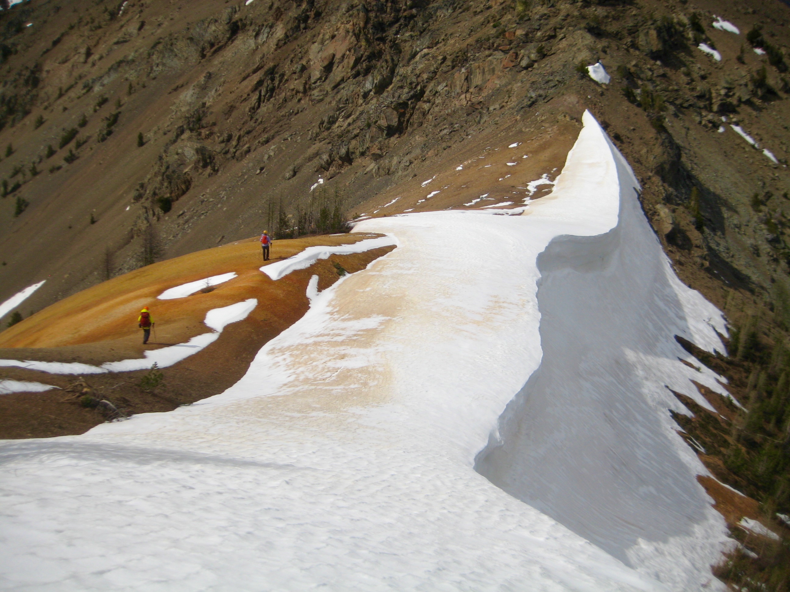 climbers hiking across Red Saddle with snow cornice in the Mazama Mountains near Scatter Creek Basin