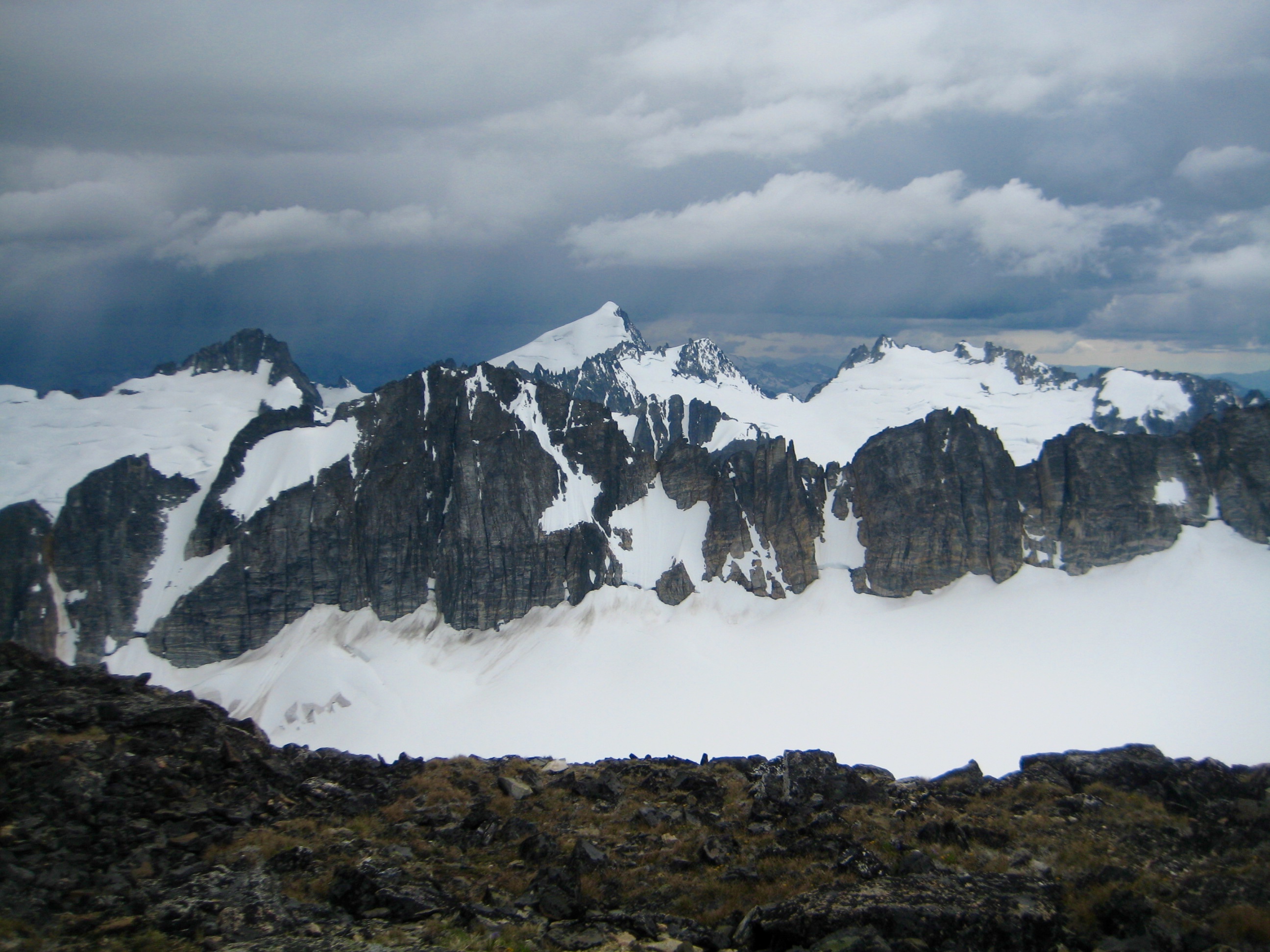 Eldorado Peak and Inspiration Traverse with black storm clouds as seen from the summit of Primus Peak in the North Cascades