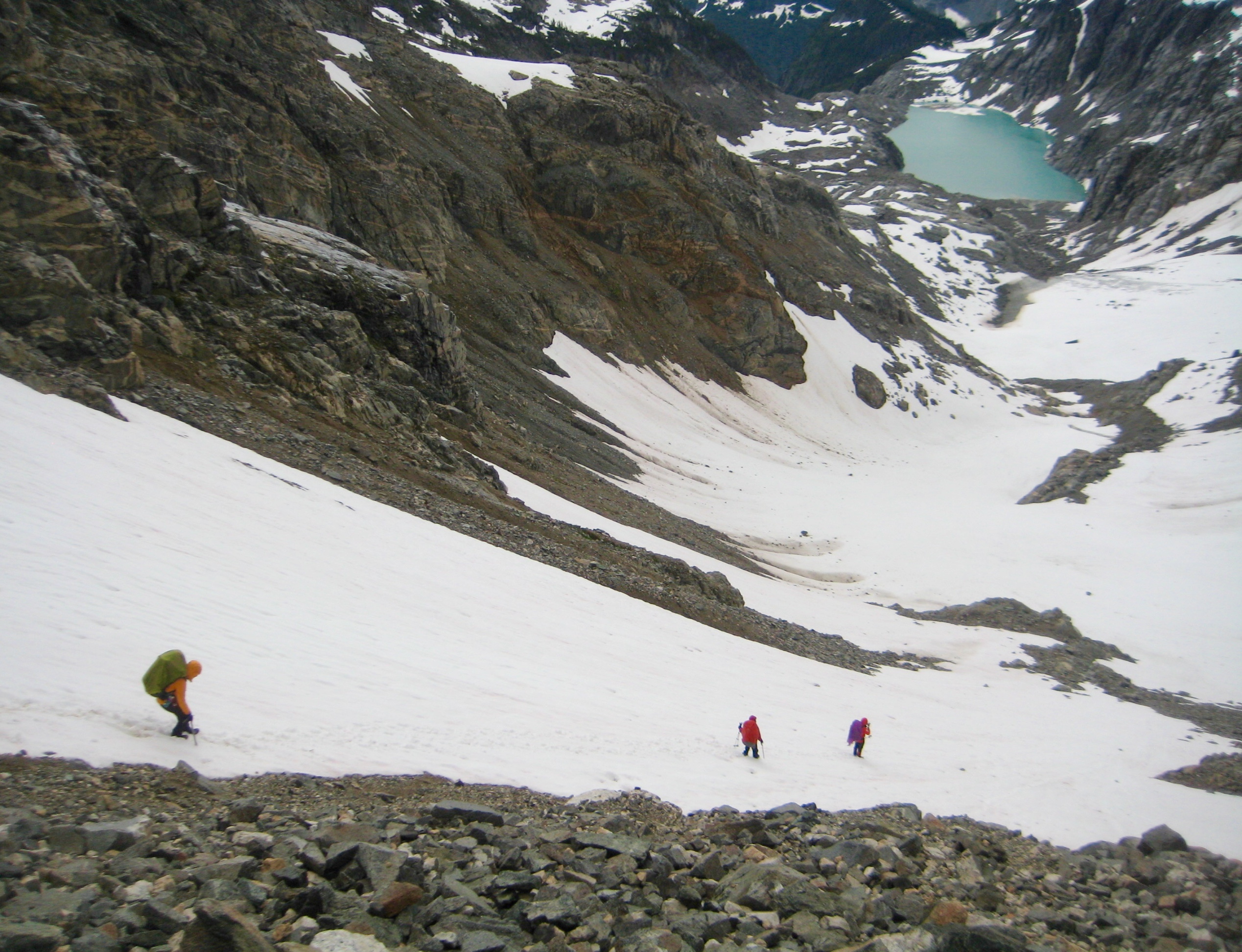 Mountain climbers descending snow field leading down from Borealis Pass in the North Cascades on McAllister Traverse aka Inspiration Traverse