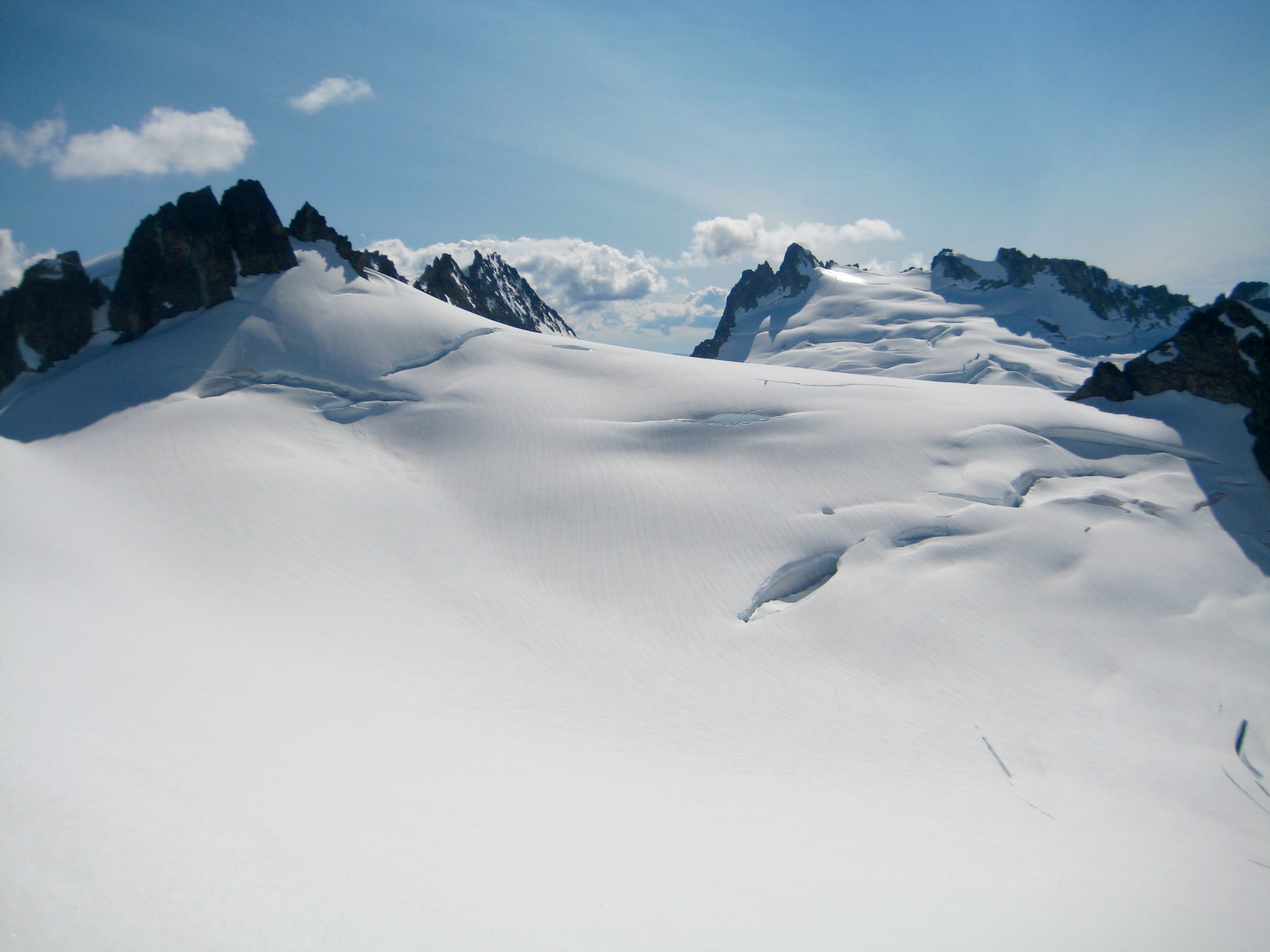Tepeh Towers and Dorado Needle above large snowfield from North Klawatti Notch on McAllister Traverse aka Inspiration Traverse