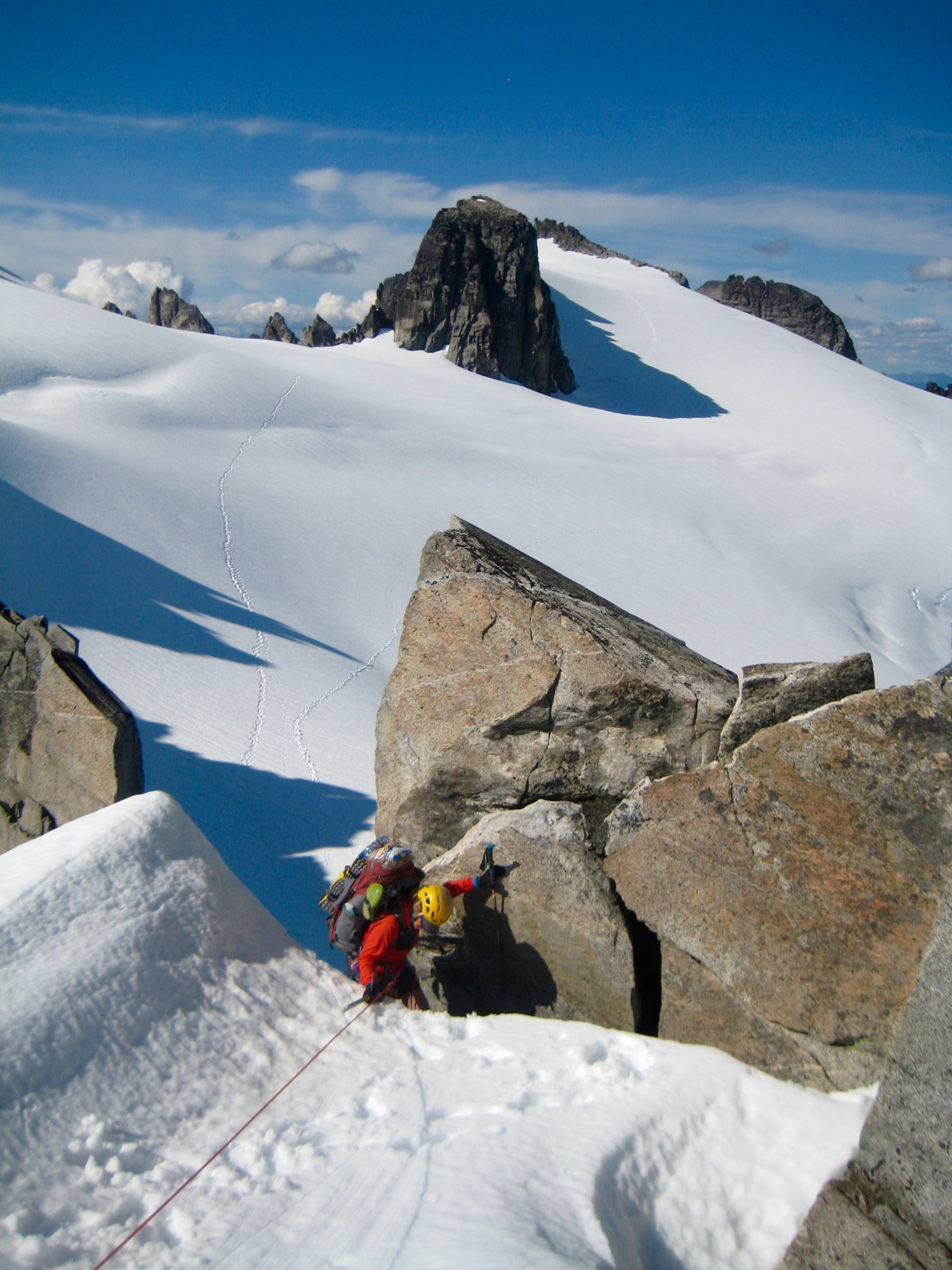 roped mountain climber scrambling thru North Klawatti Notch with the Klawatti Glacier in the background along McAllister Traverse aka Inspiration Traverse