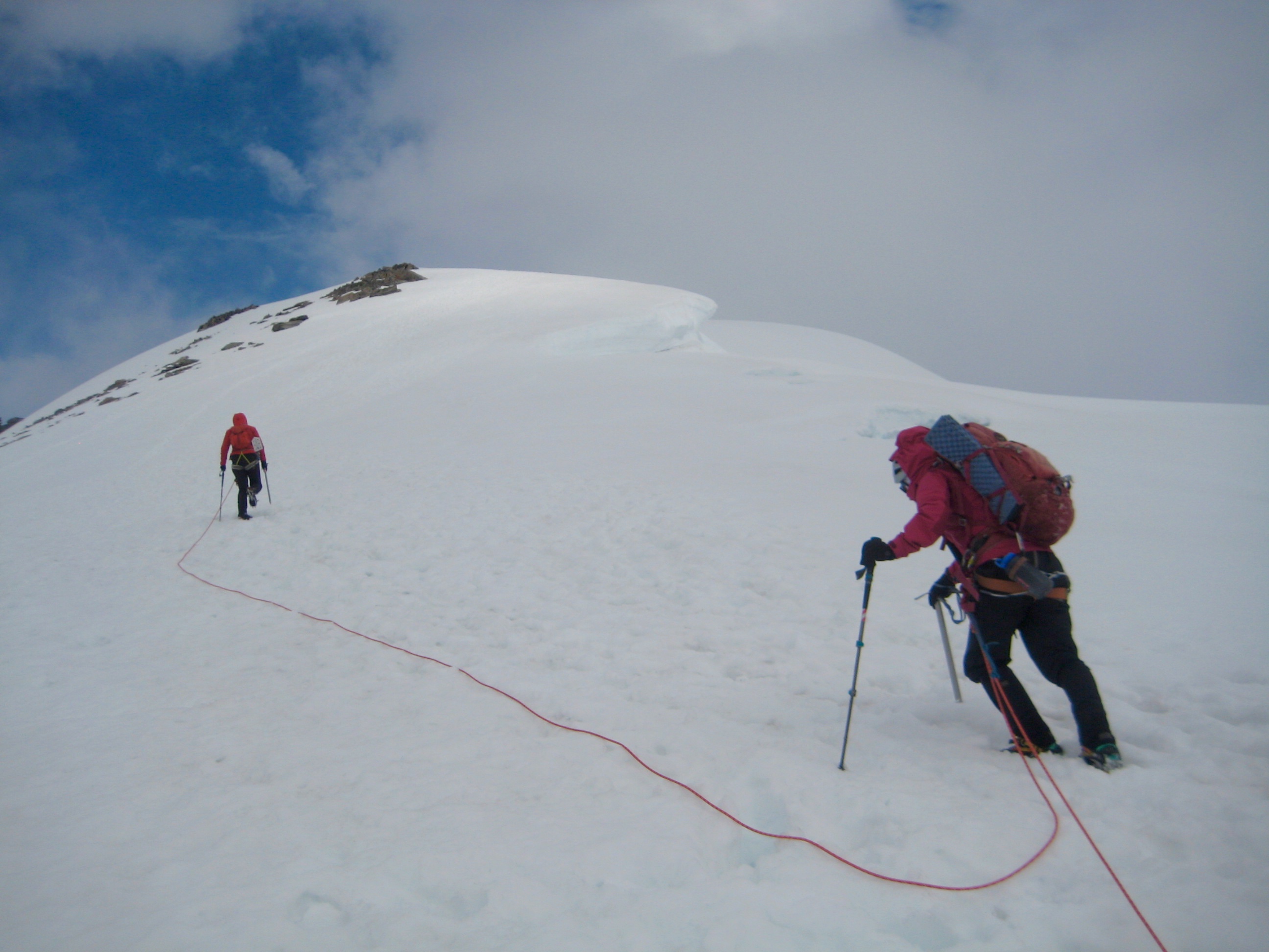 roped mountain climbers booting up snow on the shoulder of Eldorado Peak in the North Cascades