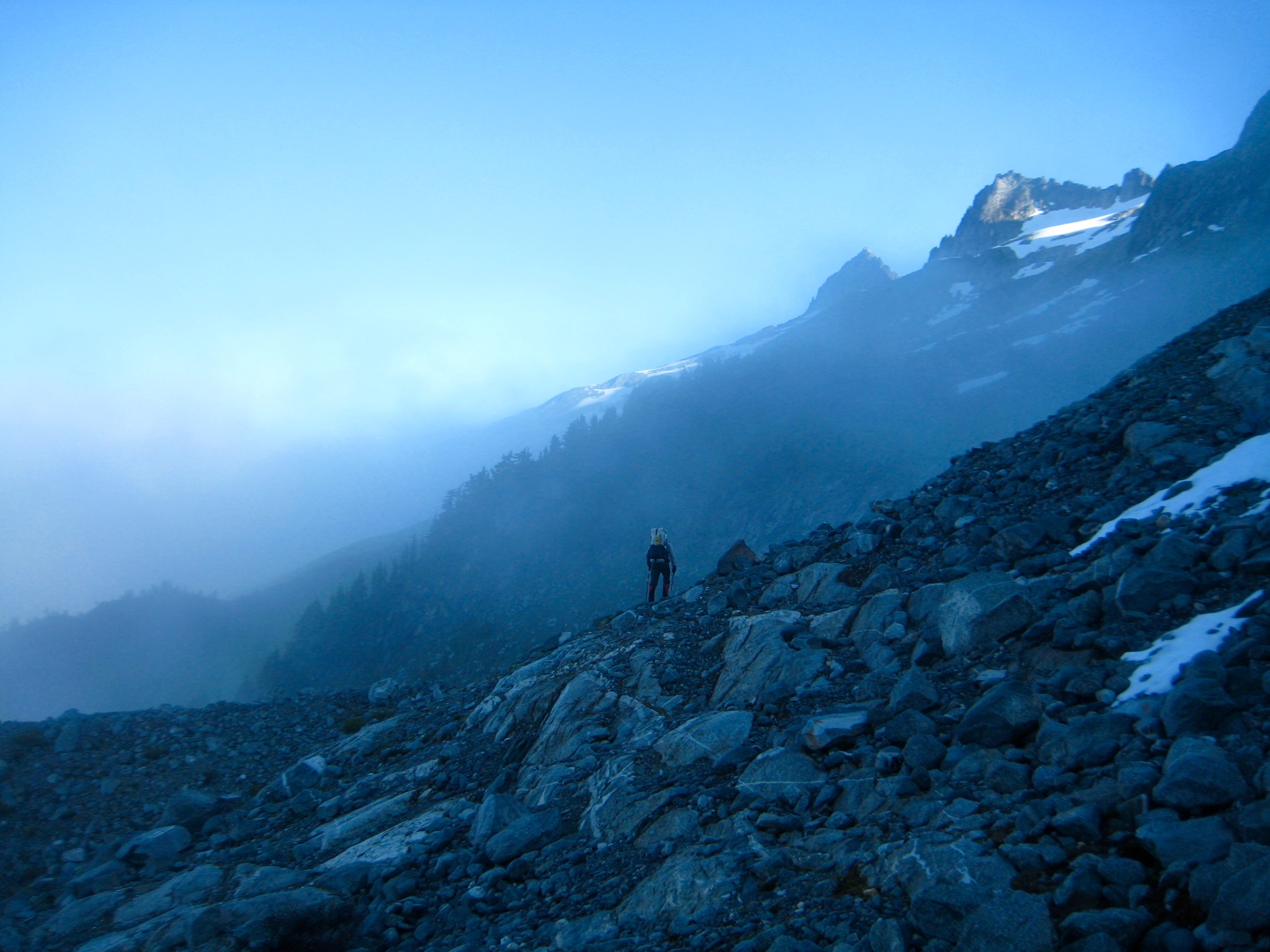 mountain climber traversing rock field toward Coccyx on McAllister Traverse aka Isolation Traverse