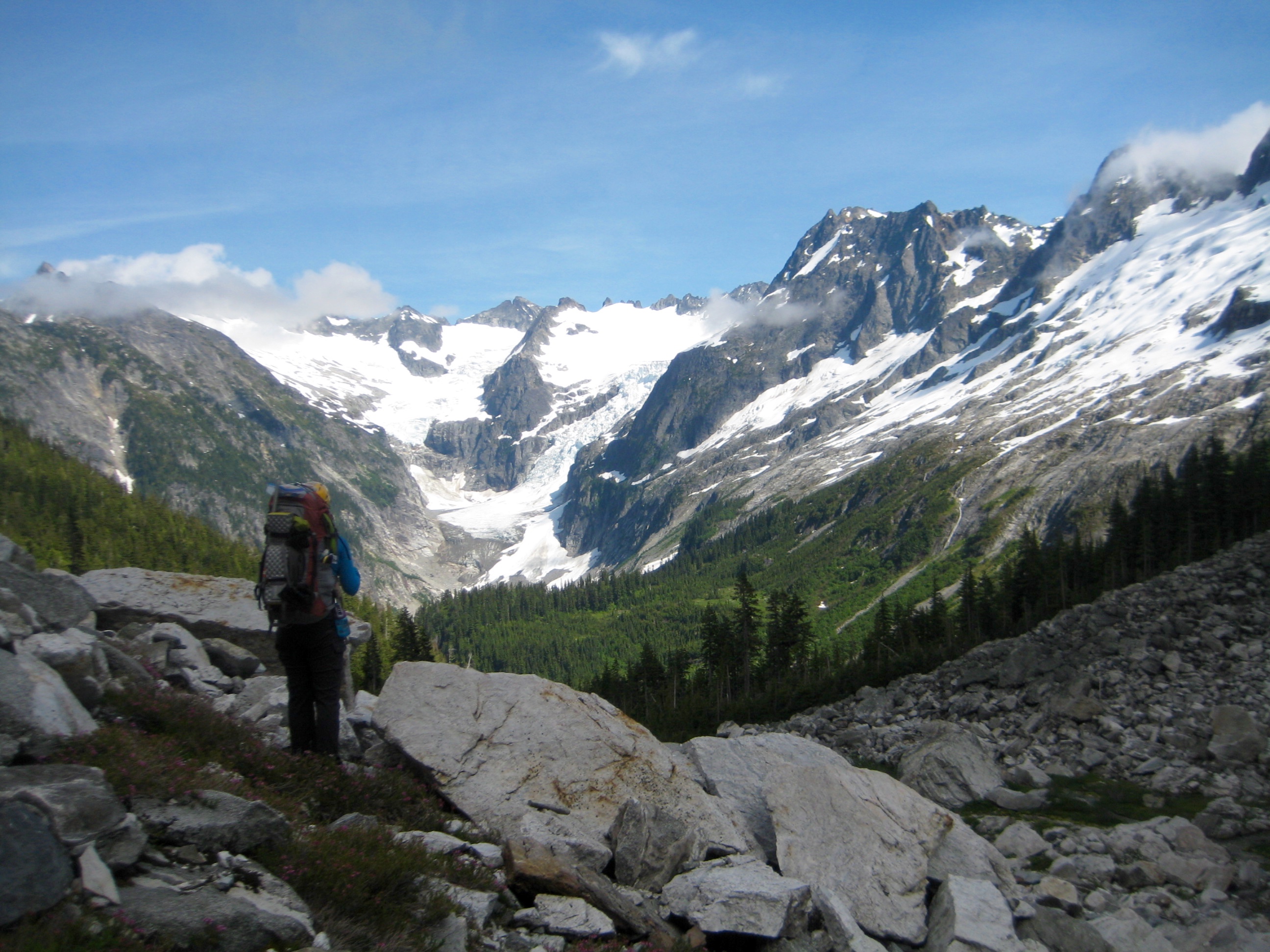Mountain climber looking deep into McAllister Creek headwaters in the North Cascades as seen from Western Cirque and McAllister Traverse aka Isolation Traverse