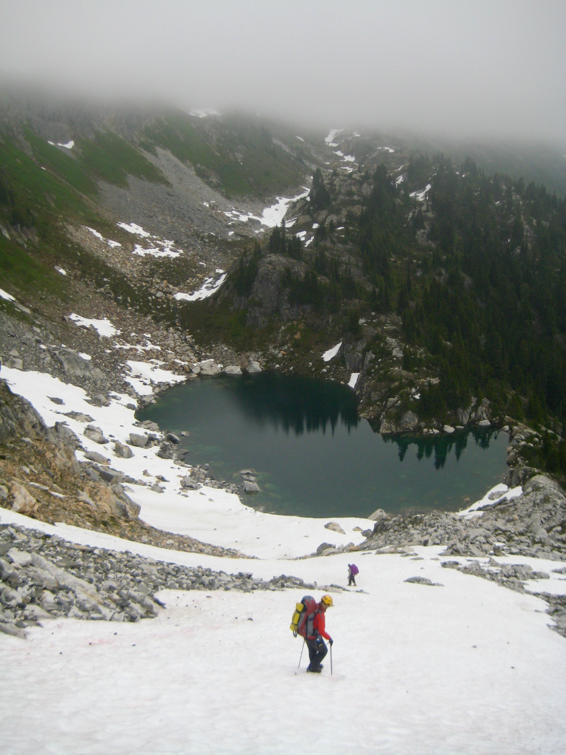 mountain climbers booting down snow field leading to Isolation Lake in the North Cascades