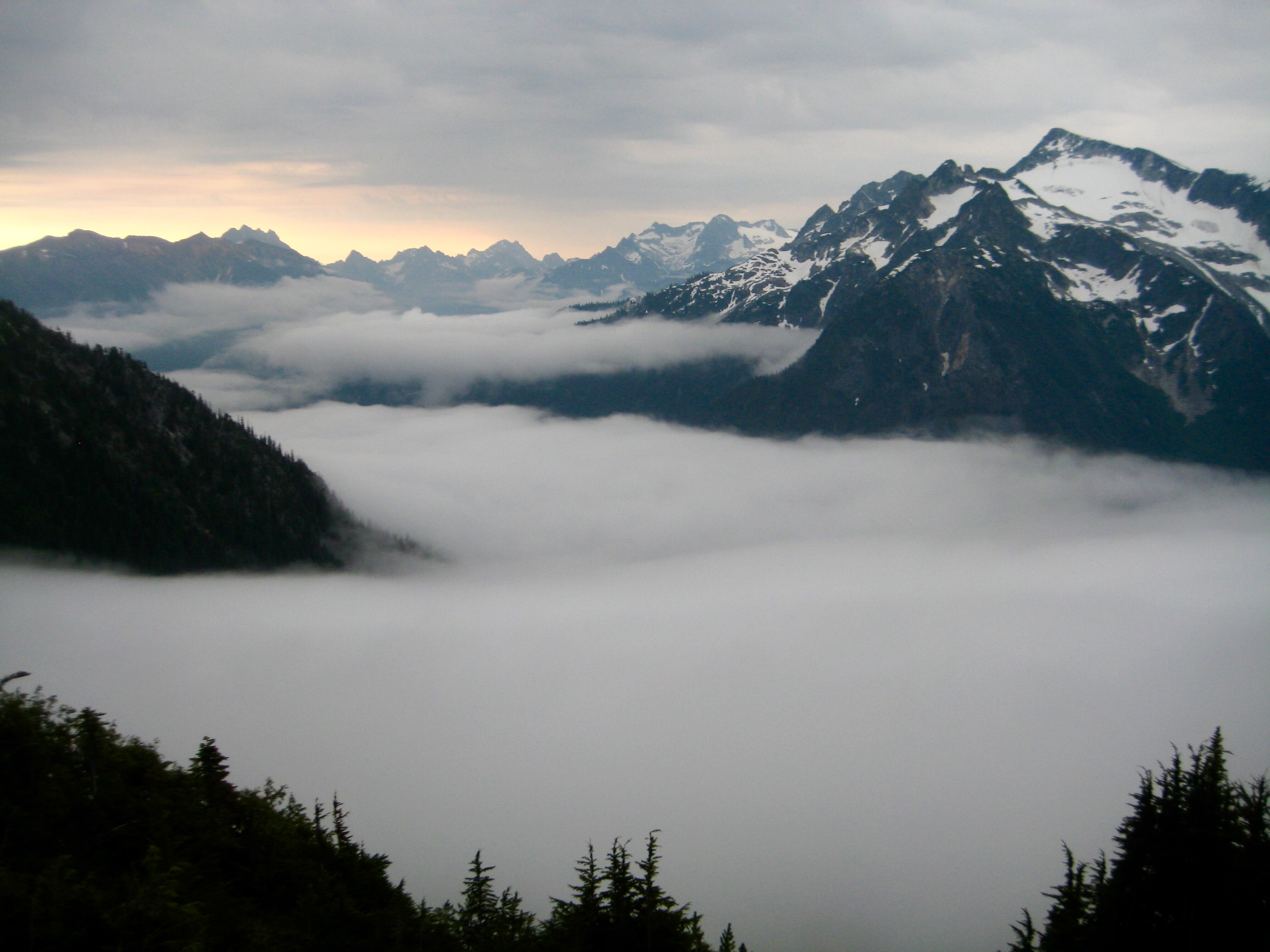 Morning Fog In McAllister Creek Valley with mountains sticking out above the fog on the Isolation Traverse in the North Cascades