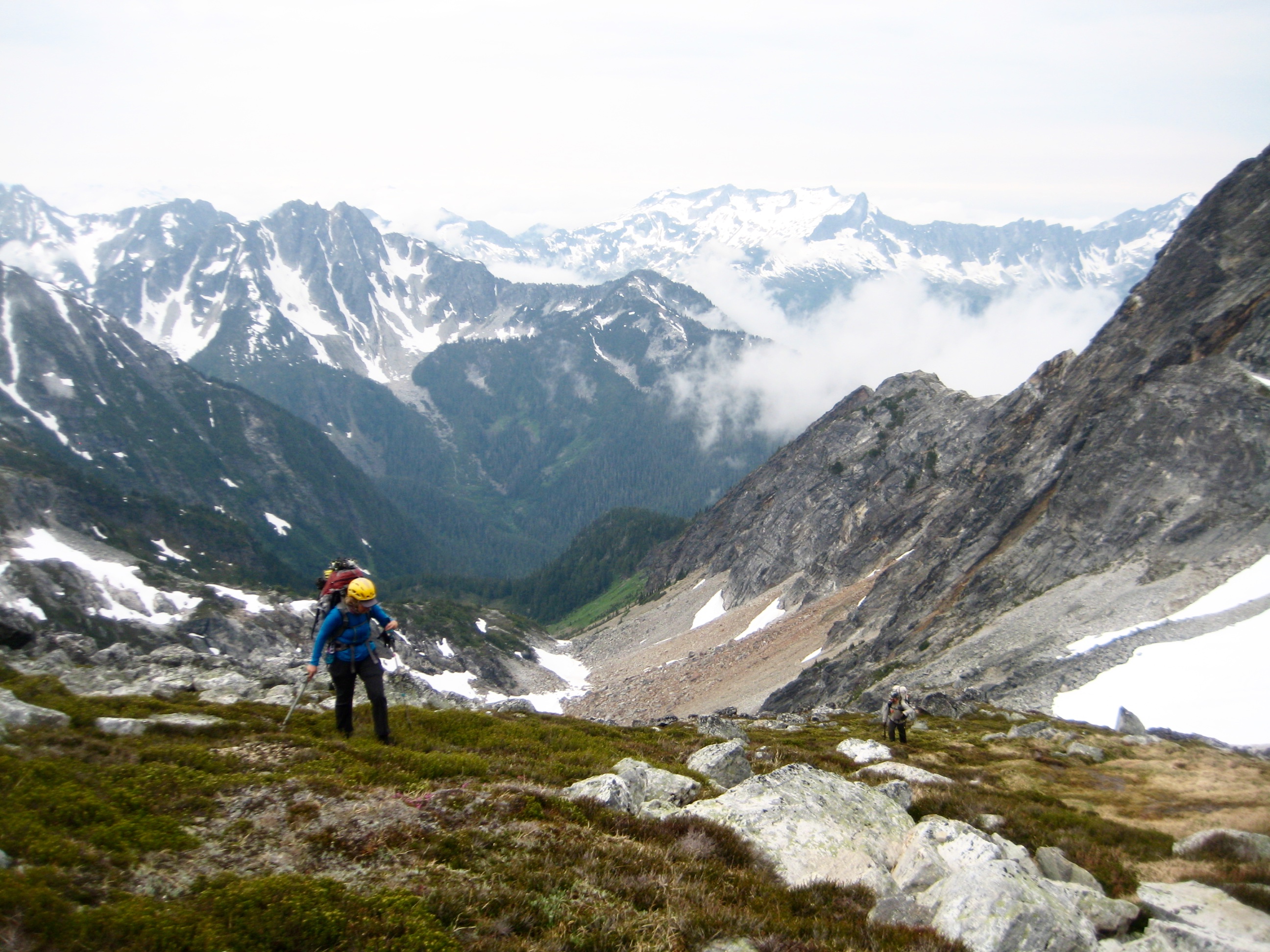 mountain climbers hiking up heather with mountains in the background on the Isolation Traverse