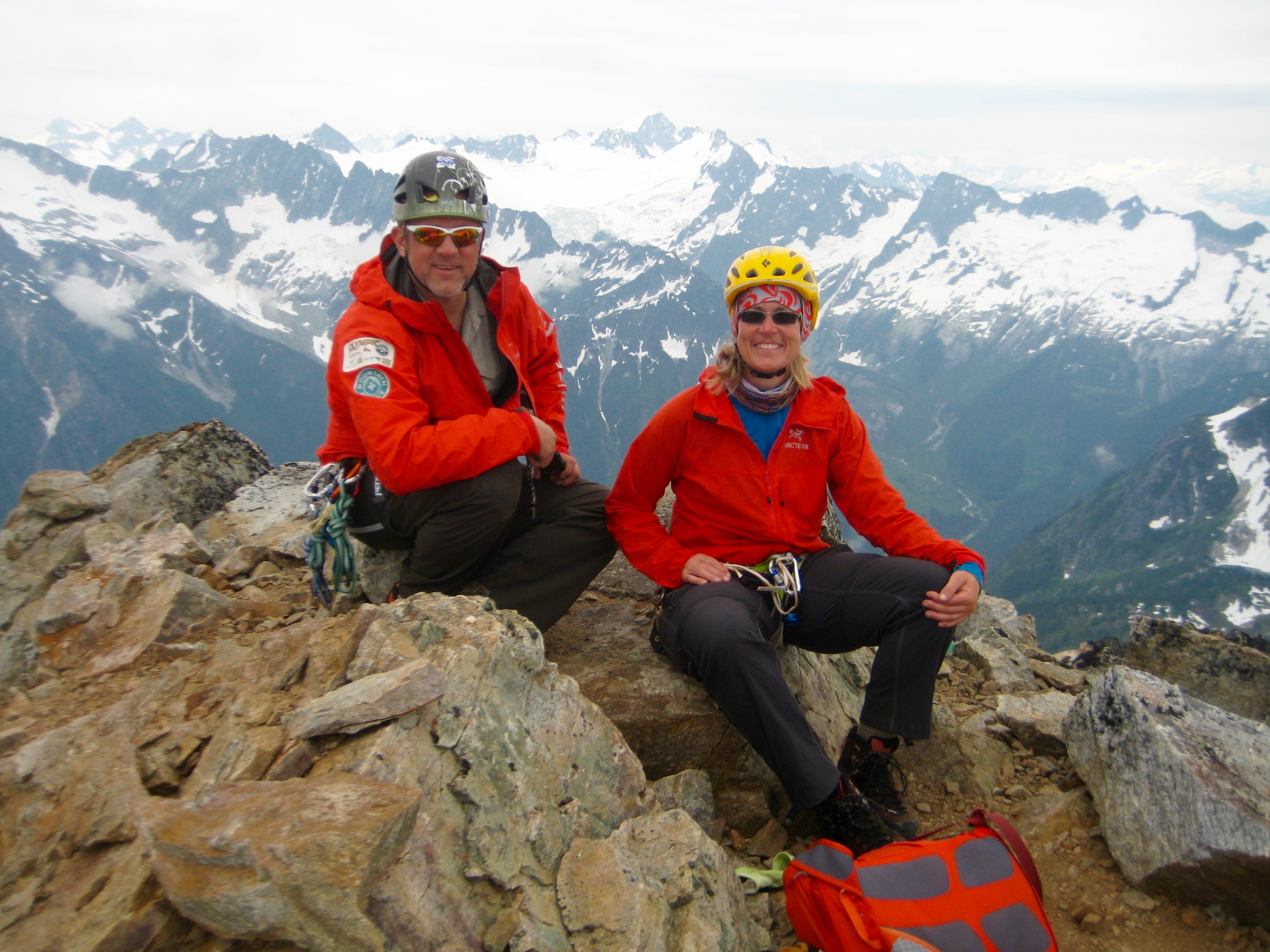 mountain climbers taking a break on the rocky summit of Snowfield Peak with the Inspiration Traverse in the background