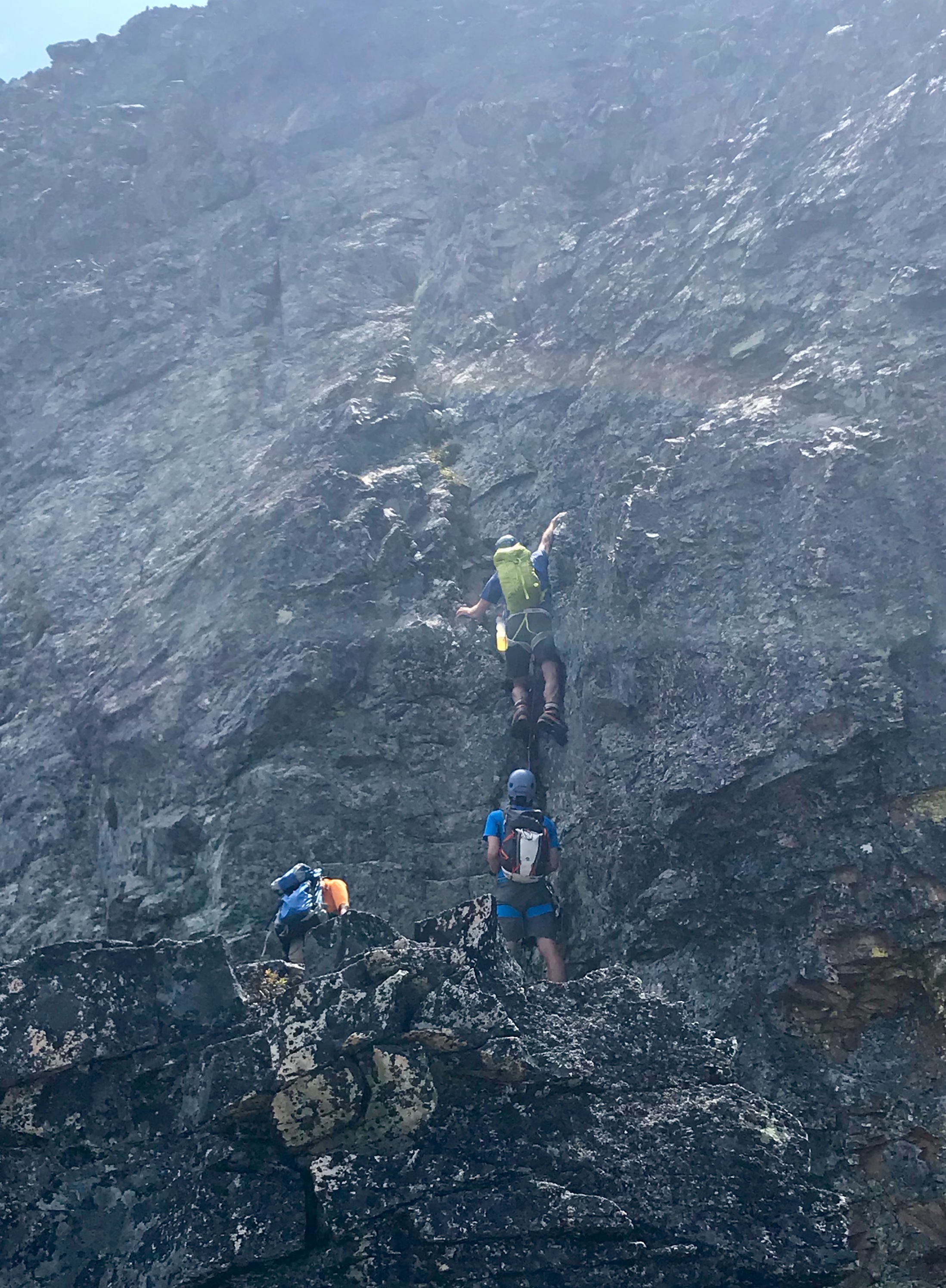 Climbers scrambling Dihedral crux on West Ridge of Fisher Peak