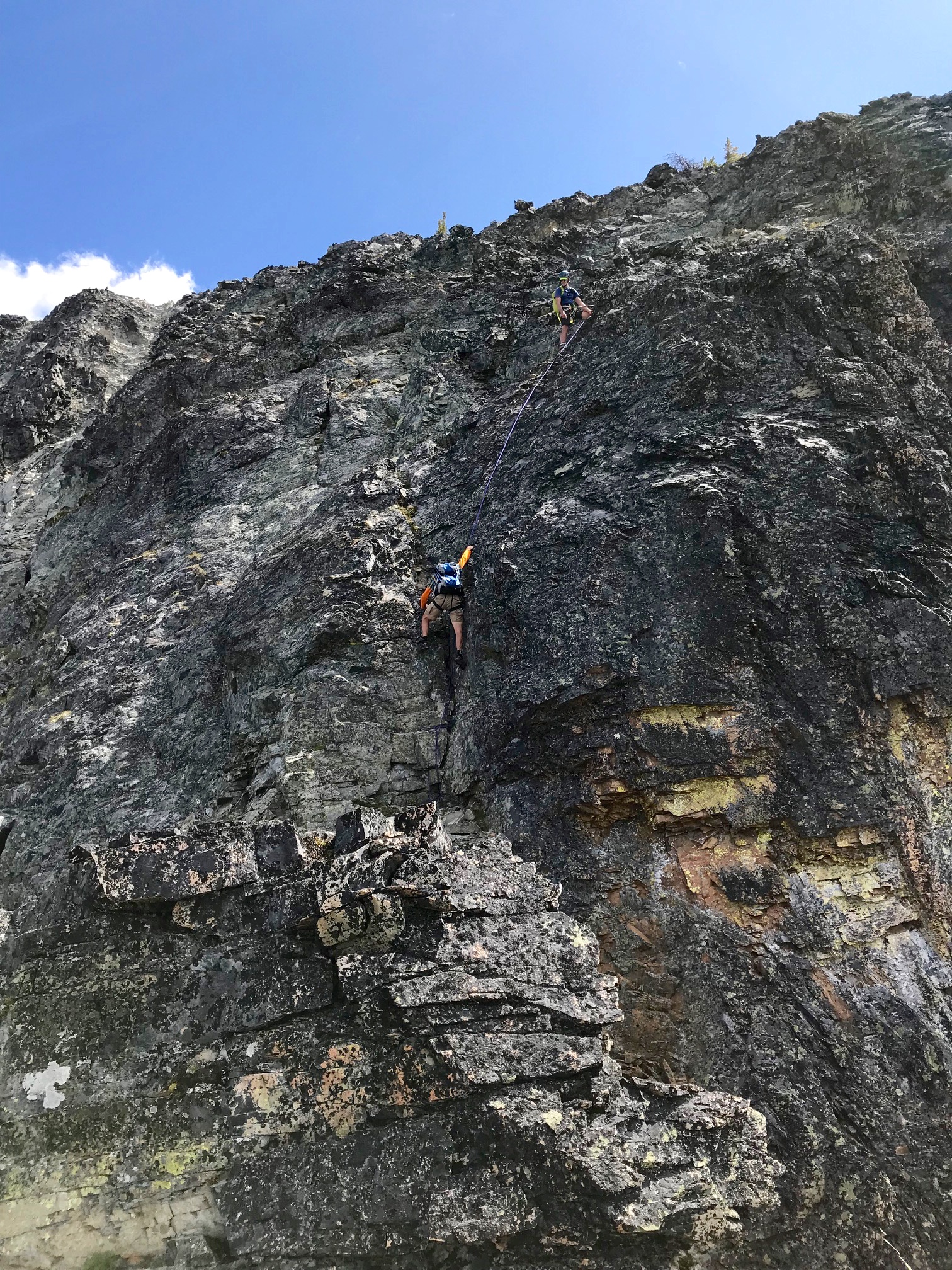 Climber downclimbing steep Dihedral on West Ridge of Fisher Peak