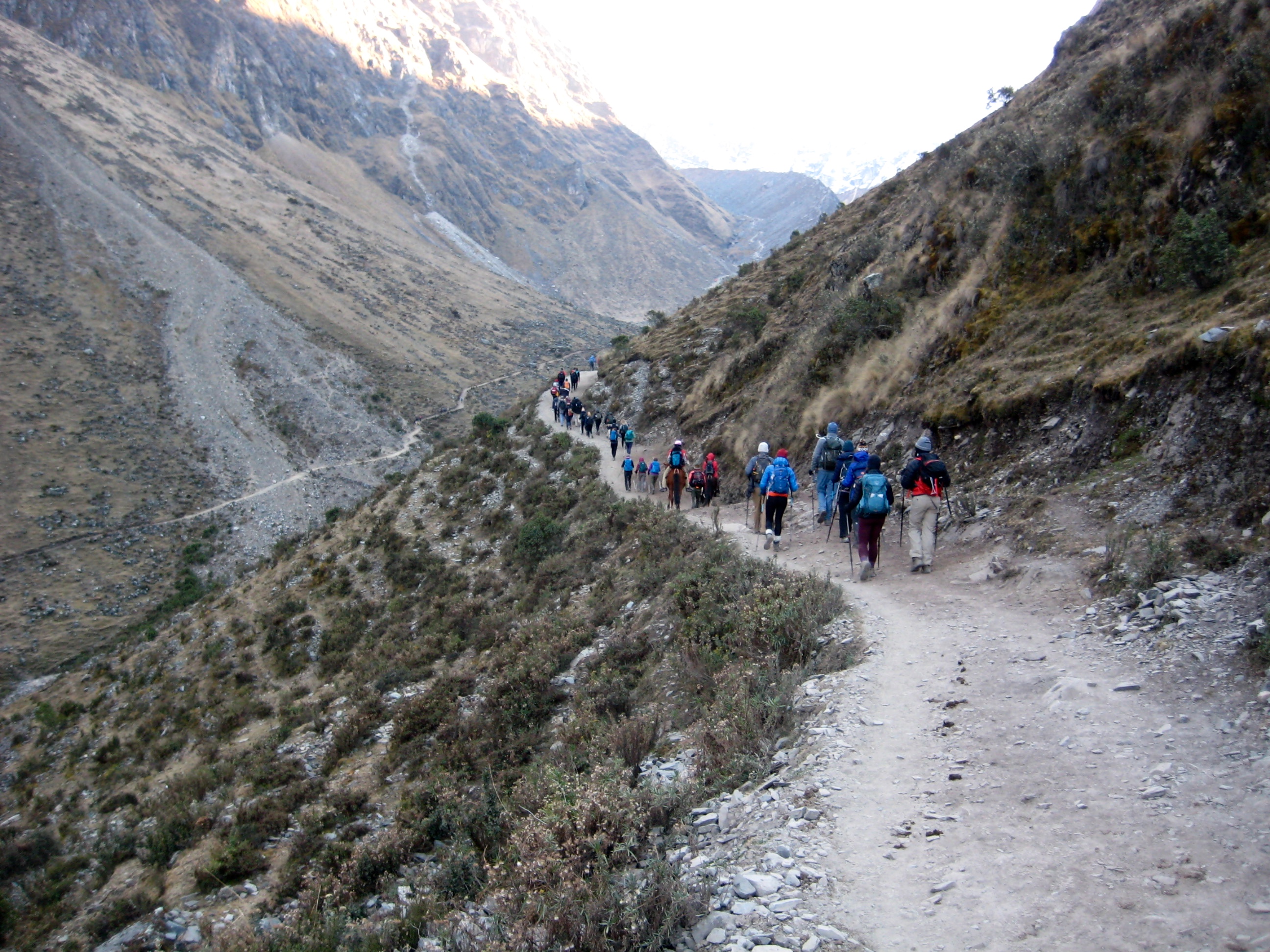 trekkers heading up rocky trail to Salkantay Pass high tundra all around