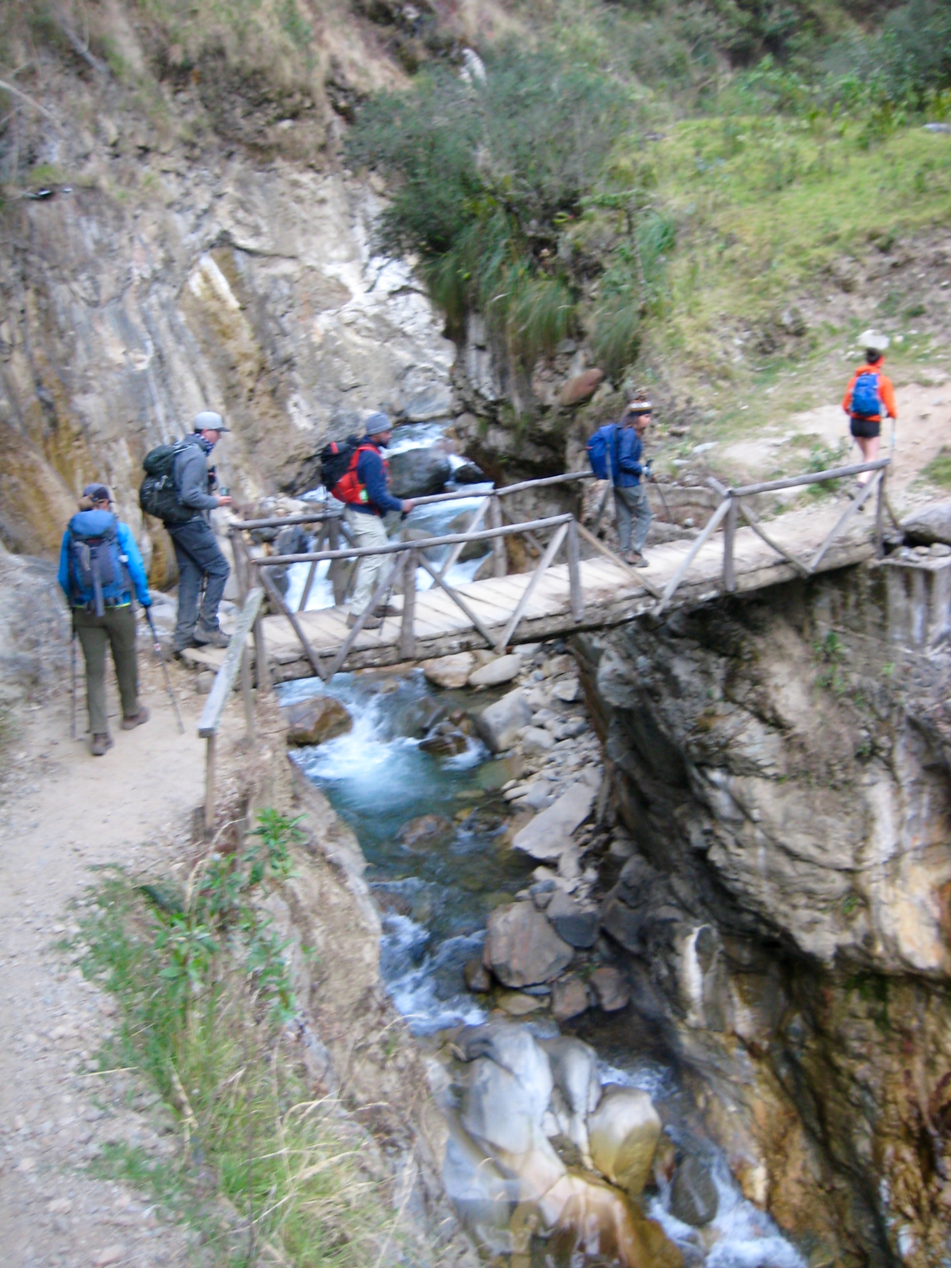 trekkers crossing St Teresa River on log bridge on the start of day 2 on the Salkantay Trek
