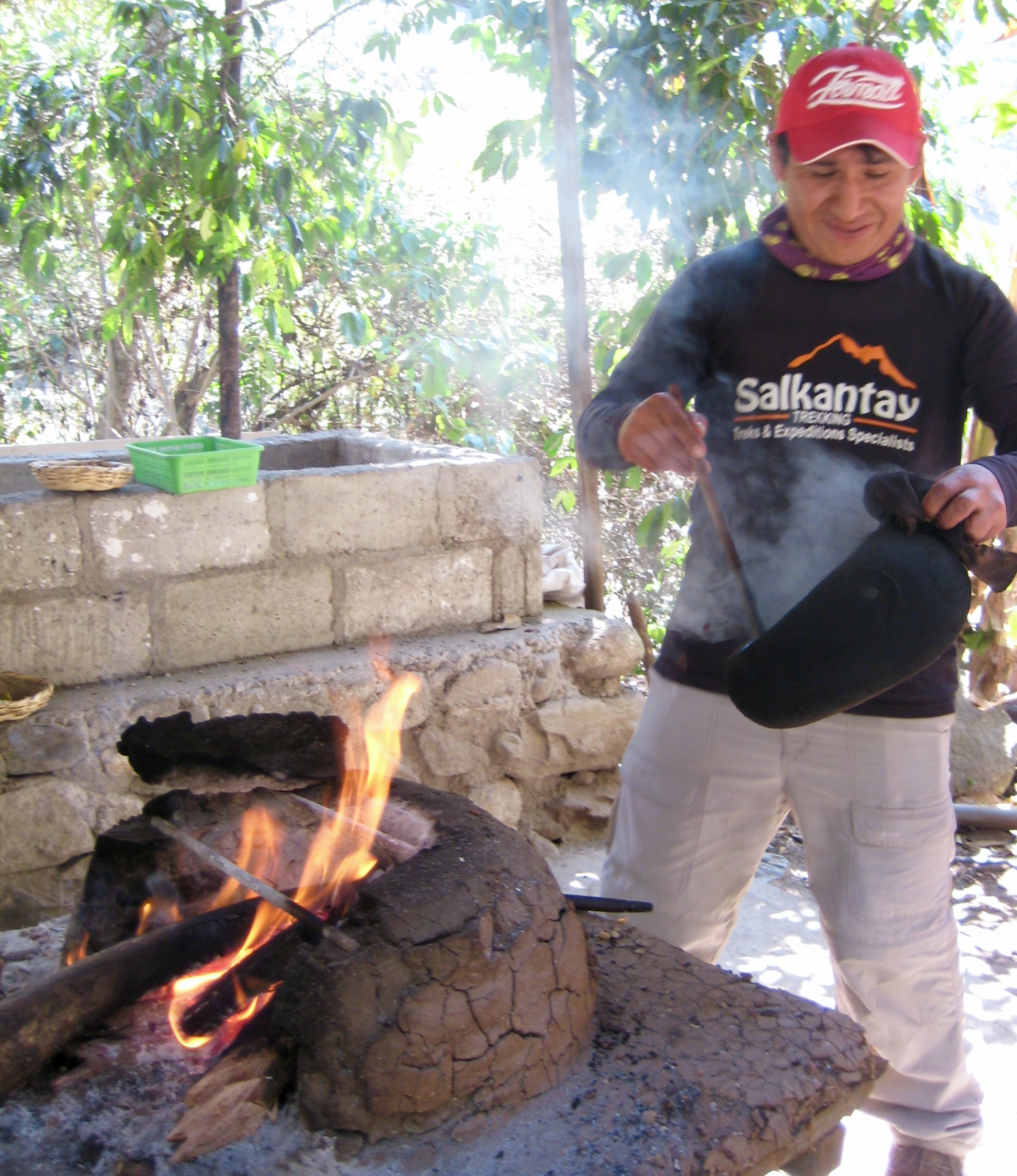 Trekking guide roasting coffee beans over open flames at Lucmabamba