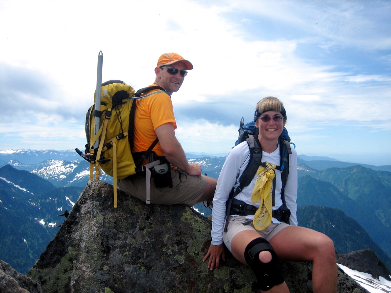 Two mountain climbers sit on summit of Vesper Peak