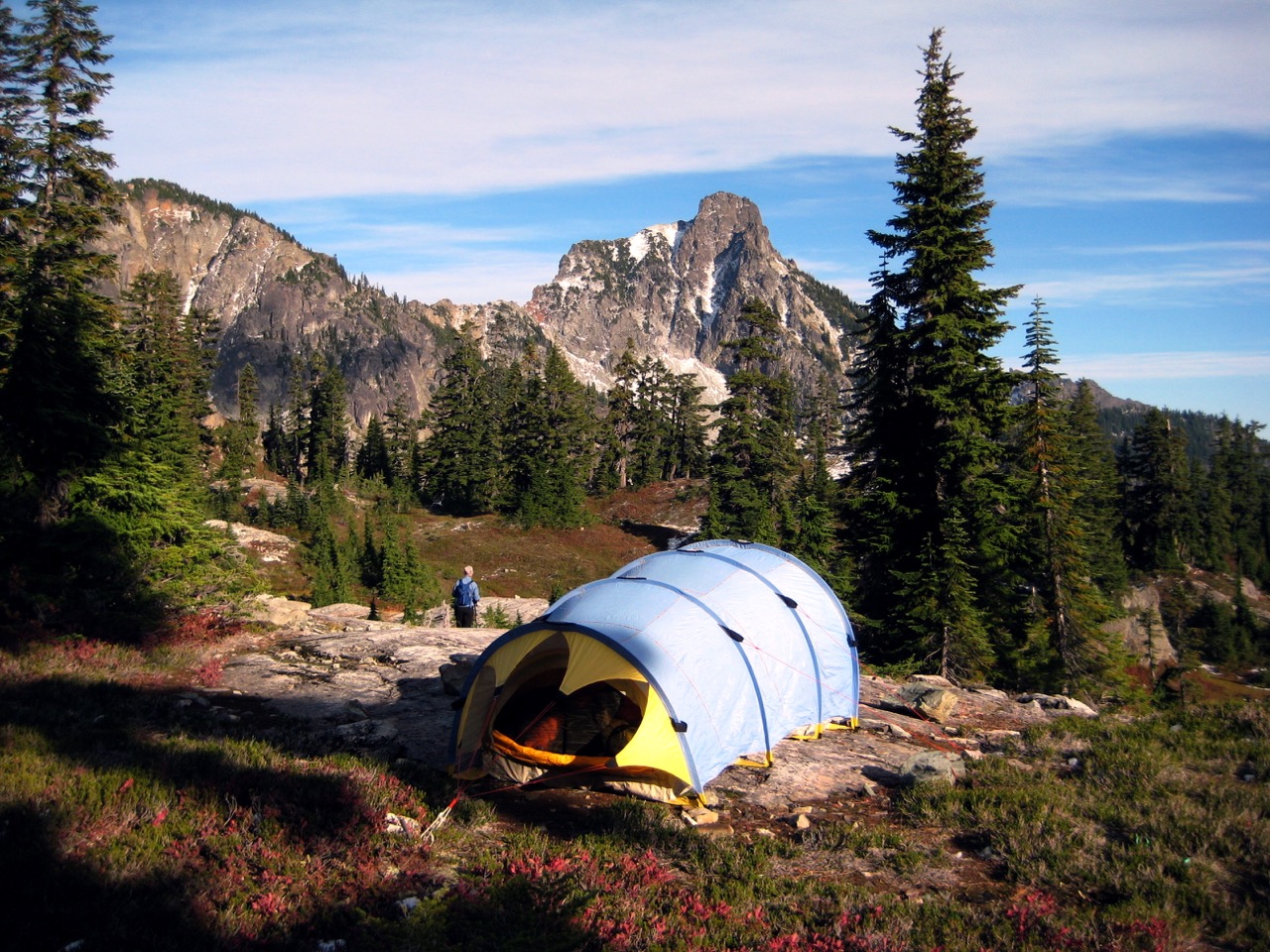 A blue tent sits on a grassy bench at Lila Lakes below Hibox Peak