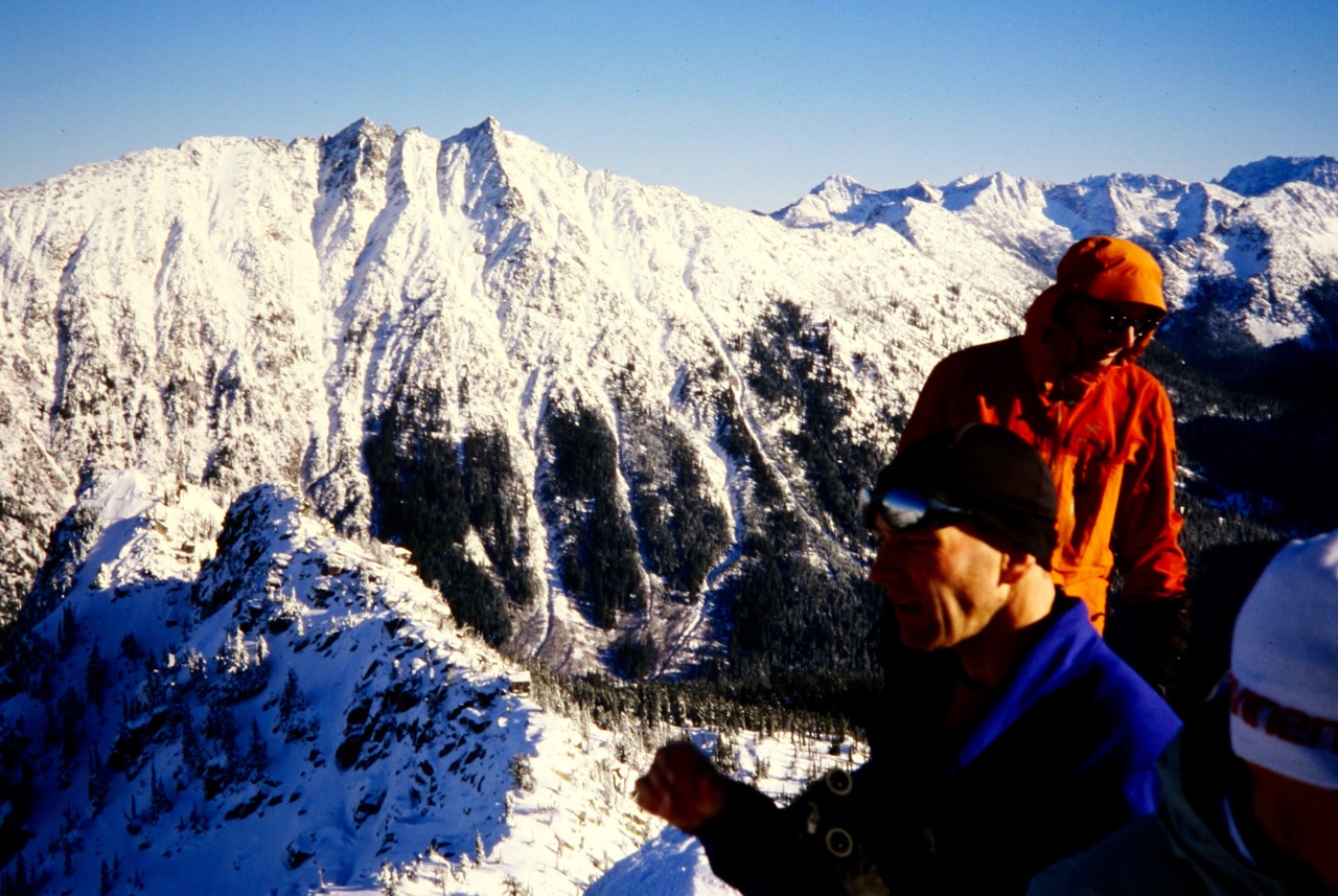 Climbers look at the broad snowy face of The Cradle from Sherpani Peak