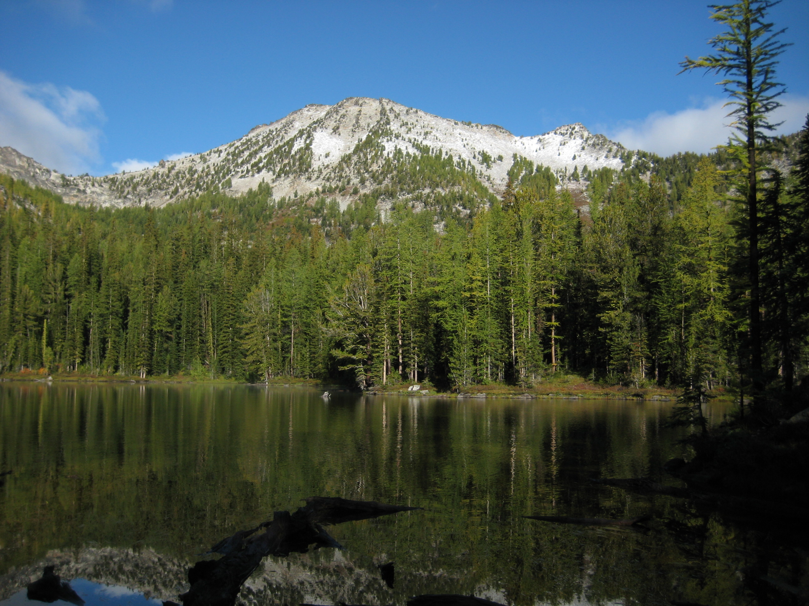 Cheops Peak above Lower Martin Lake and evergreen trees in the Sawtooth Mountains