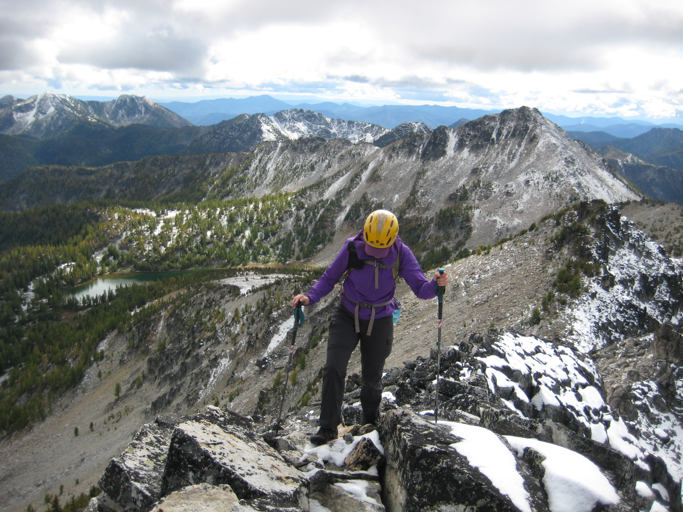 mountain climber reaching the summit of Martin Peak in the Sawtooth Mountains with Cooney/Switchback Peak in the background