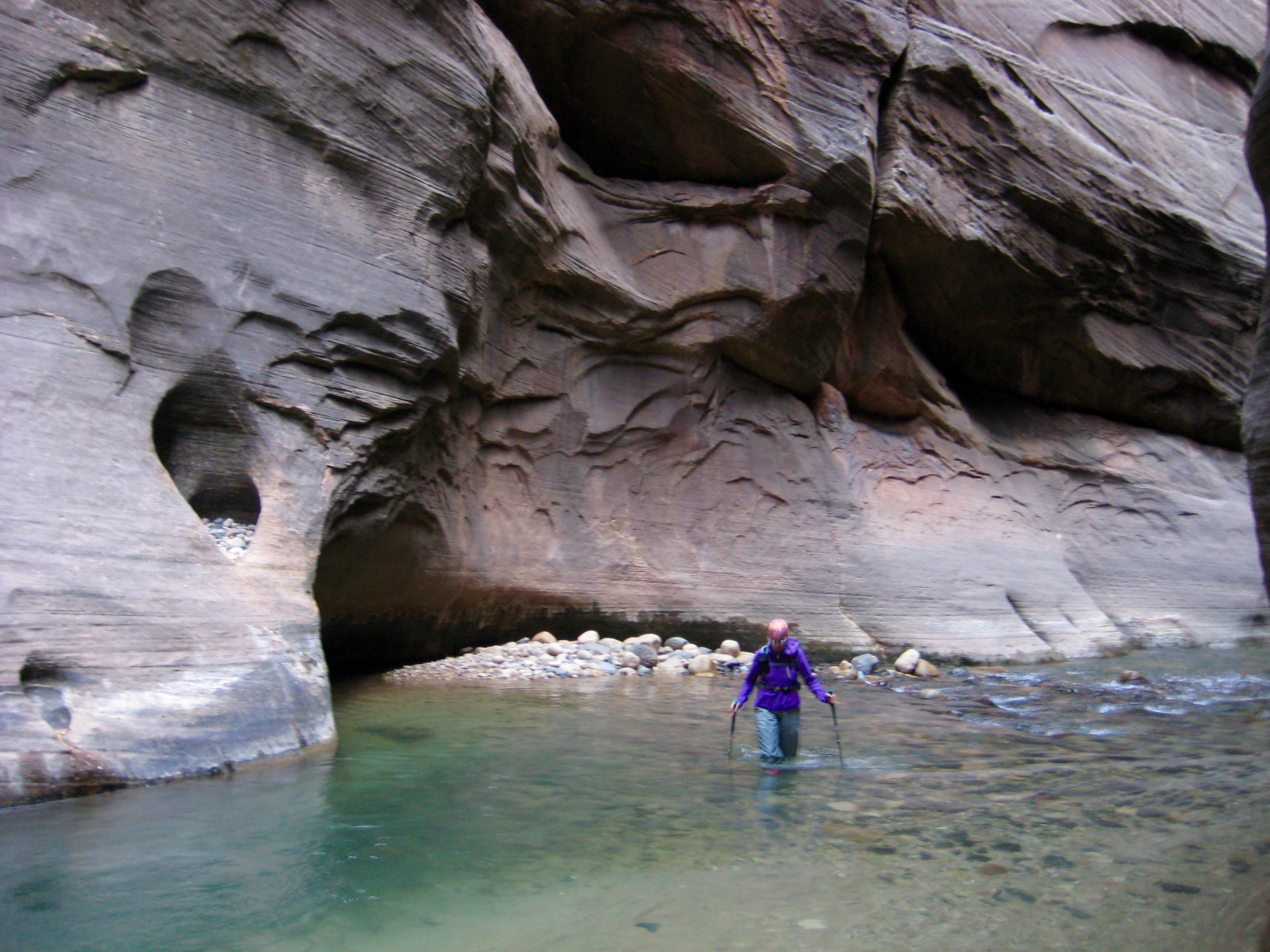 A canyon explorer wades up the Virgin River in Zion Canyon Narrows
