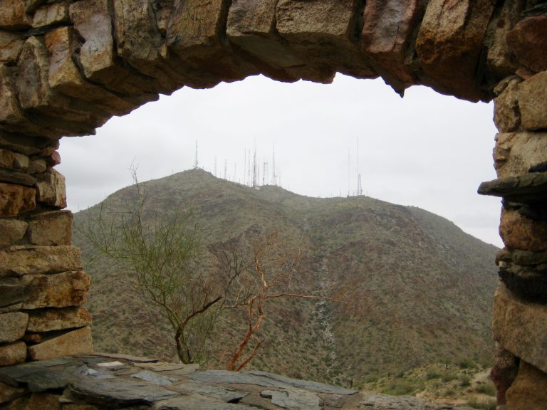 Radio towers stand on top of Mt Suappoa or Mt Suppoa as viewed through the window of the stone shelter at Telegraph Pass Lookout