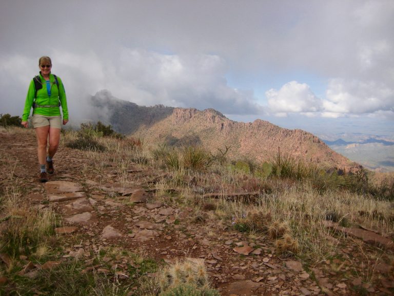 A hiker walking along Superstition Ridge crest during ridge traverse in the Superstition Wilderness of Arizona