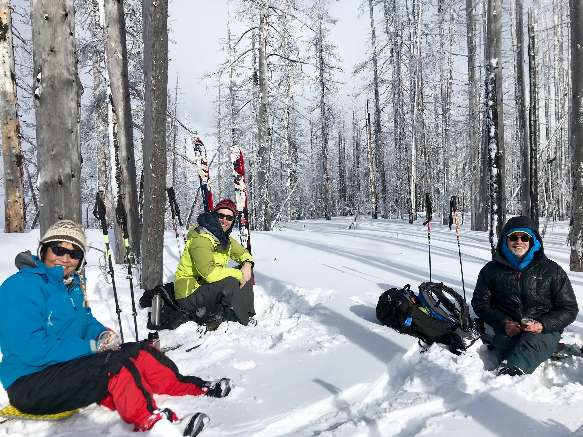 skiers taking a lunch break during the Tronsen Head Ski Loop in the snow in the tree on Tronsen Head in the Lower Wenatchee Mountains