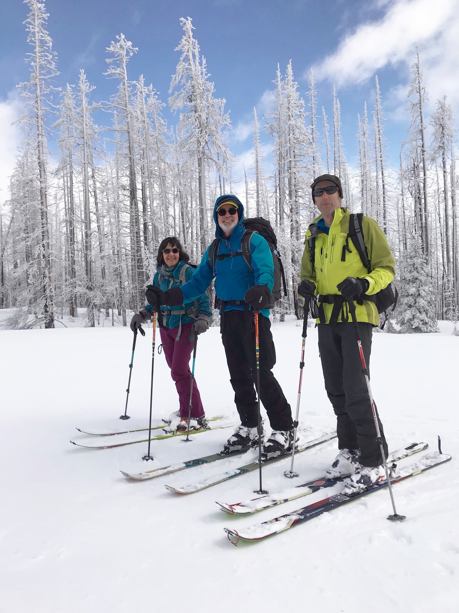 skiers taking a break on the snow covered summit of Tronsen Head in the Lower Wenatchee Mountains with snow covered trees in the background