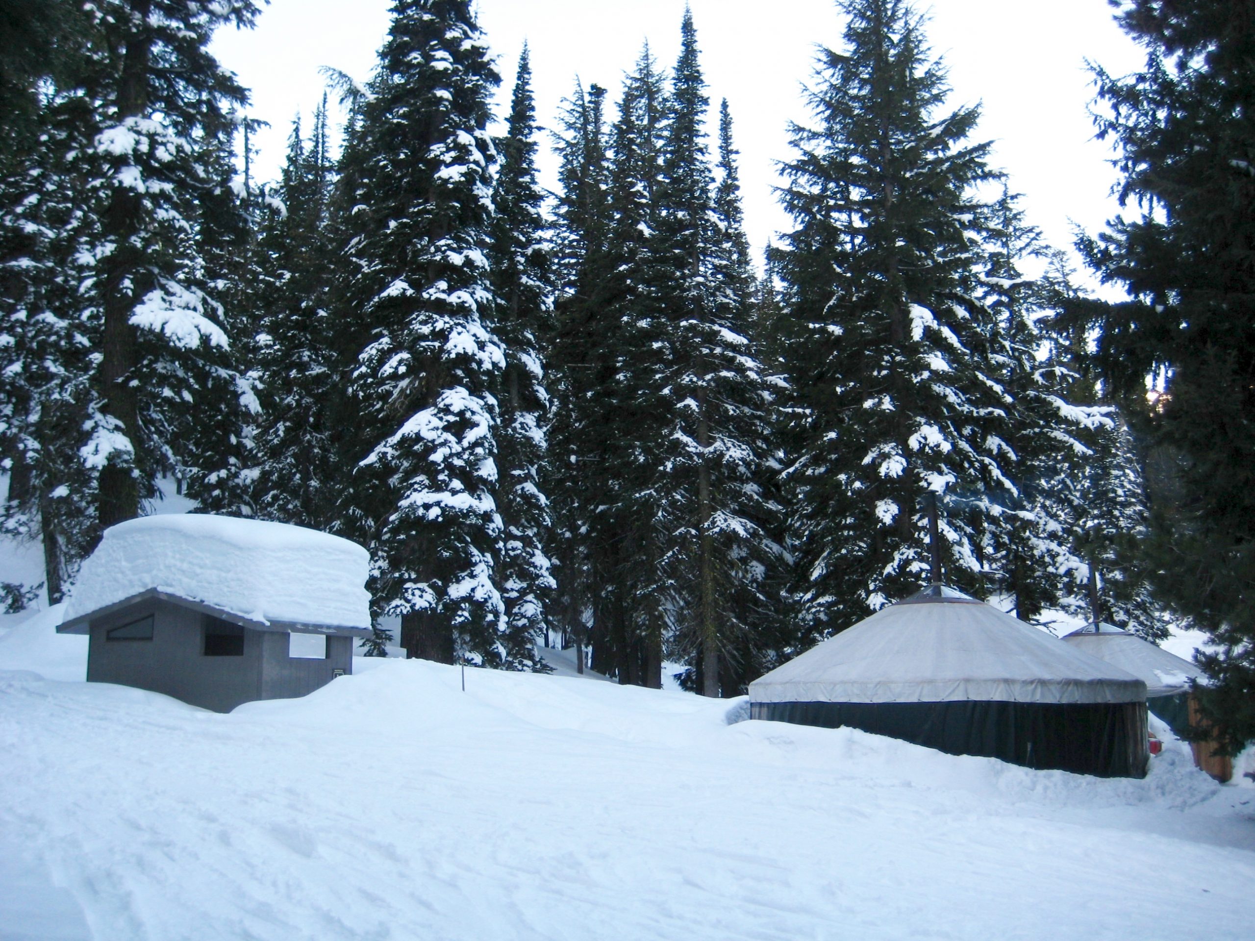 Three Creek Yurt Camp with Yurts and Sauna Building covered with Snow in Three Sisters Wilderness