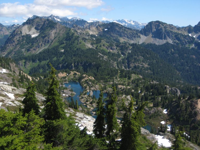 Dark blue Rampart Lakes lie scattered in a large green heather basin below Rampart Peak
