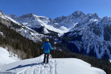 A backcountry skier stares at Mt. Sneffels in the San Juan Mountains of Colorado