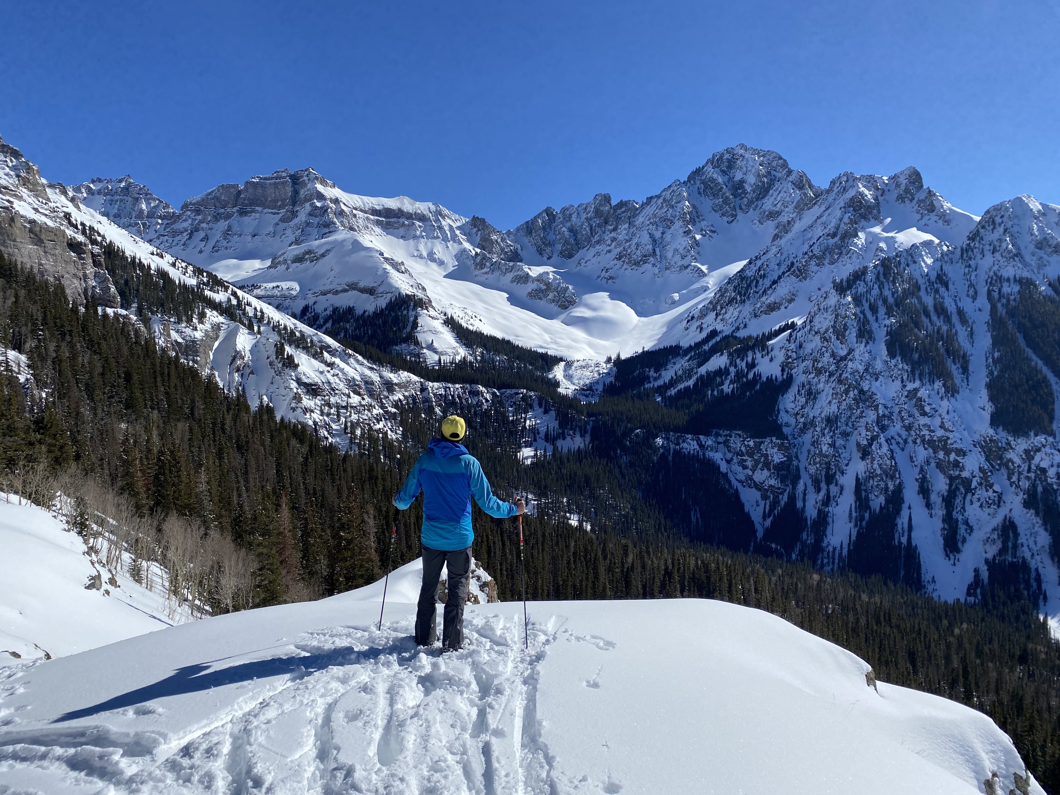 A backcountry skier stares at Mt. Sneffels in the San Juan Mountains of Colorado