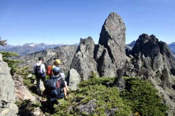 Four climbers scramble toward the summit pinnacle on Mt. Cruiser in the Olympic Mountains, WA.