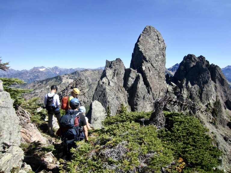 Four climbers scramble toward the summit pinnacle on Mt. Cruiser in the Olympic Mountains, WA.