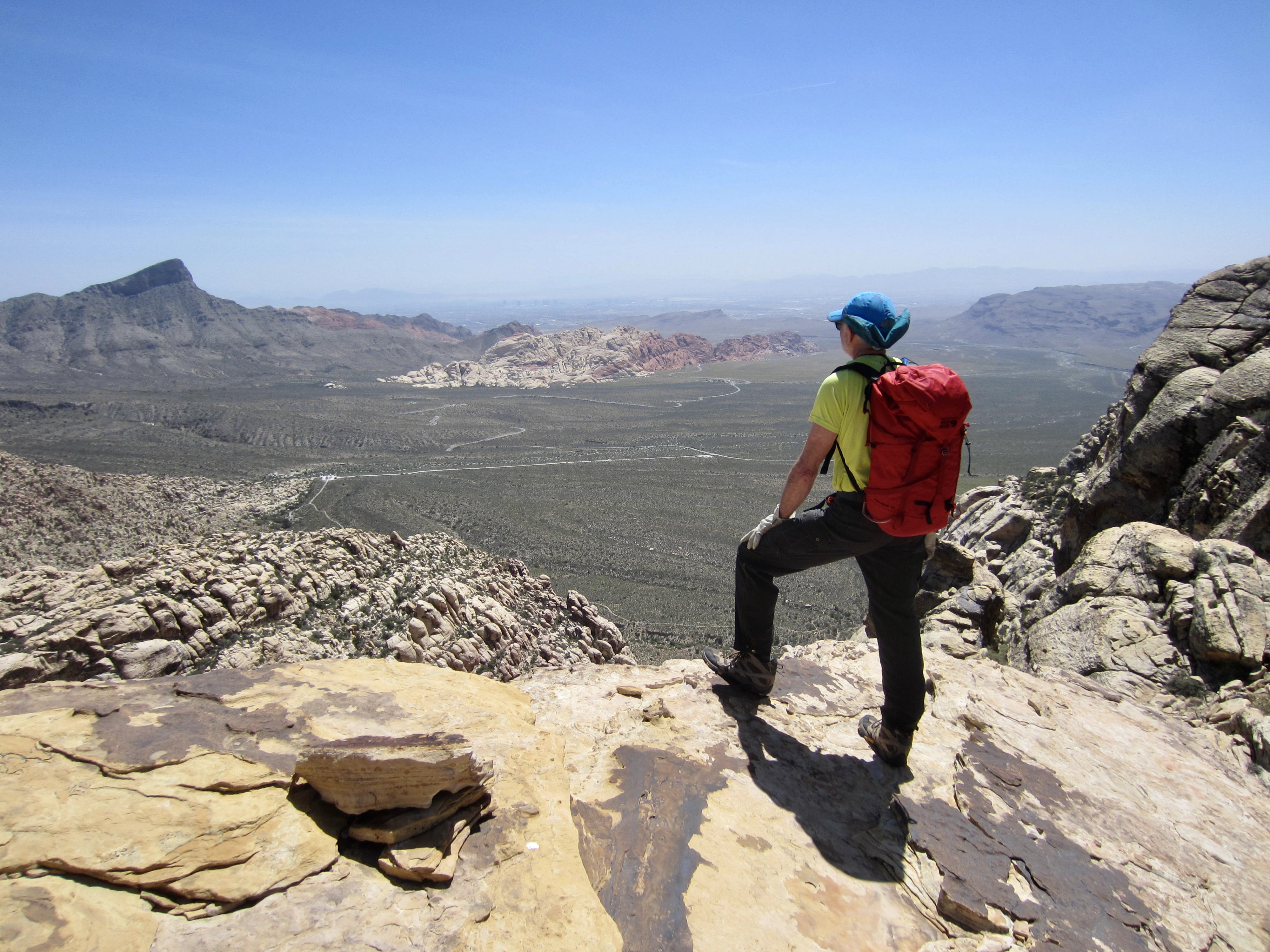 A hiker looks out over Red Rock Basin from the north ridge of White Rock Peak