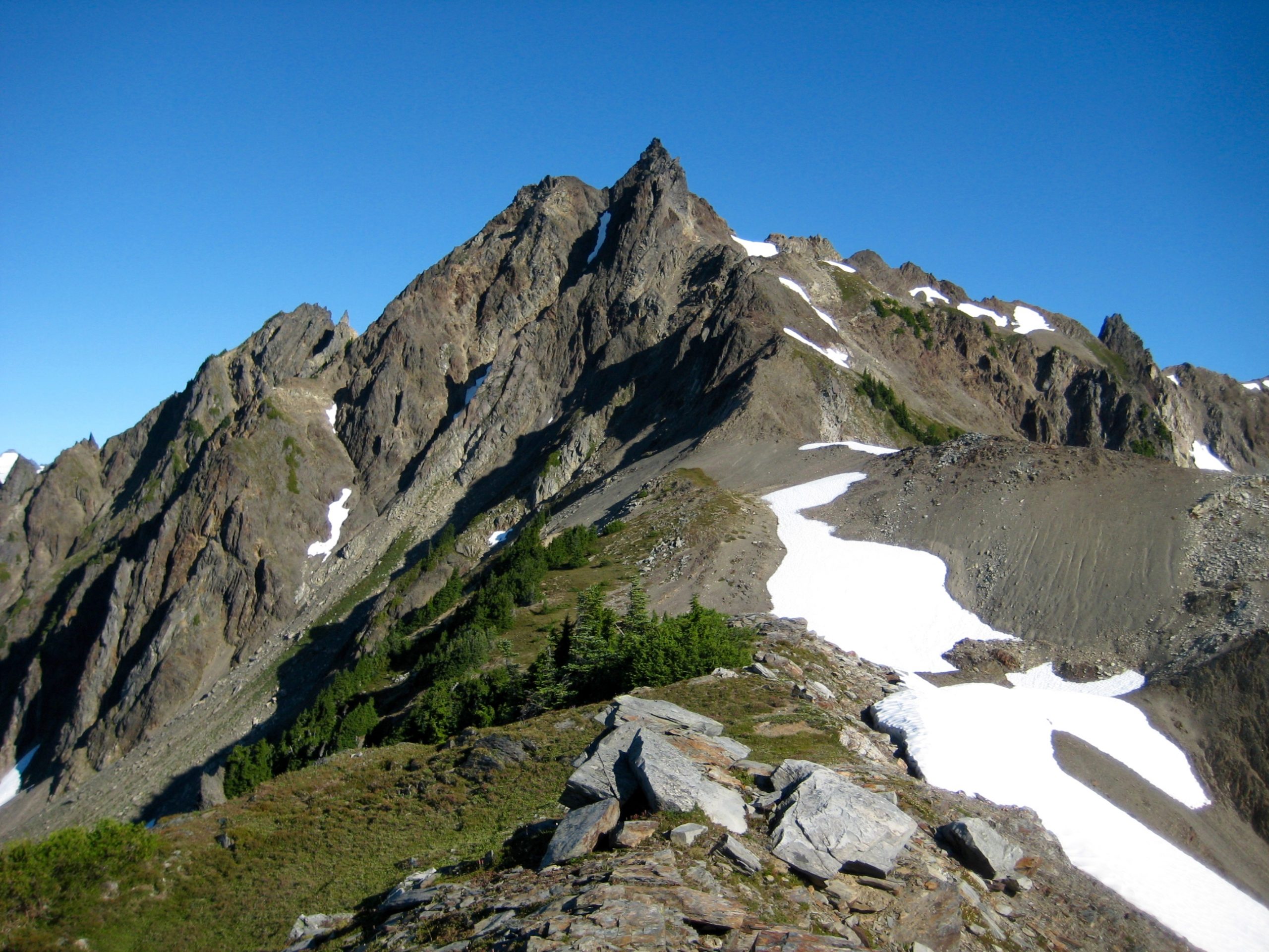 The southeast ridge of Mt Meany in the Olympic Mountains sweeps upward to meet the sharply pointed summit horn