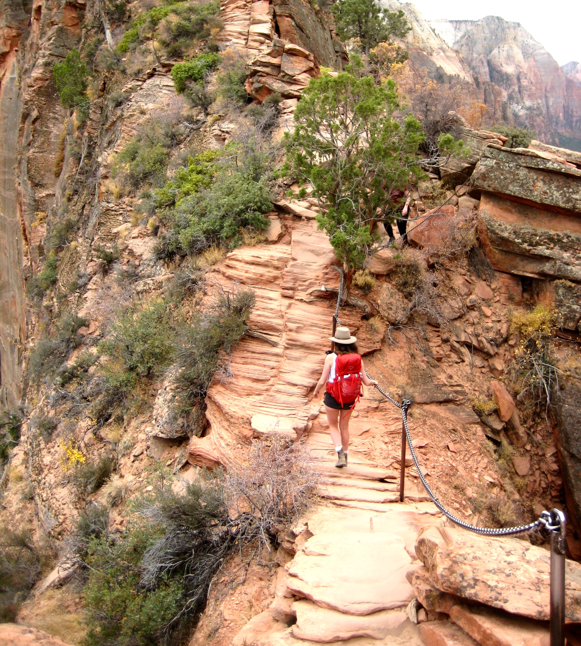 A hiker walks across an exposed ridge crest en route to Angels Landing in Zion National Park