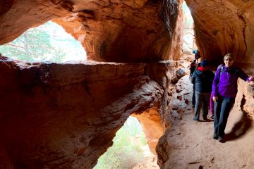 A group of hikers explore Soldier Cave at Brin's Butte in the Red Rock - Secret Mountain Wilderness Area near Sedona, Arizona.