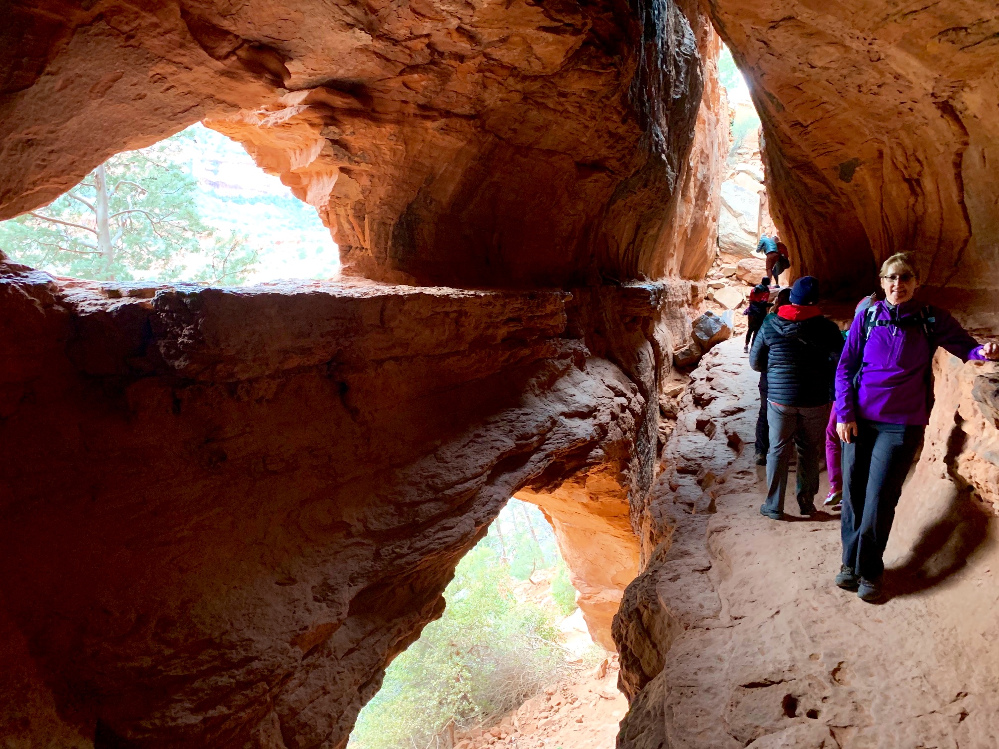 A group of hikers explore Soldier Cave at Brin's Butte in the Red Rock - Secret Mountain Wilderness Area near Sedona, Arizona.