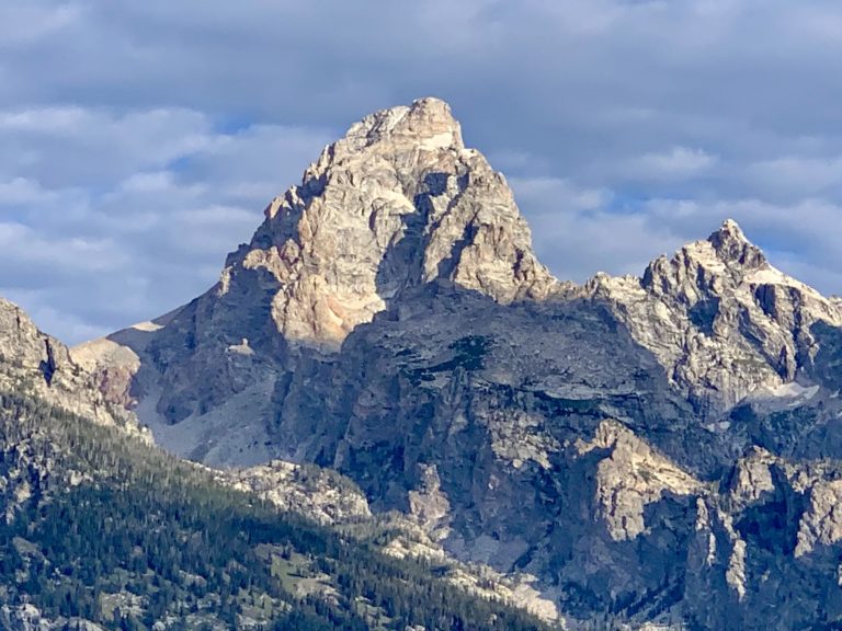 Sunrise hits the eastern face of Grand Teton as seen from Jackson Hole, Wyoming